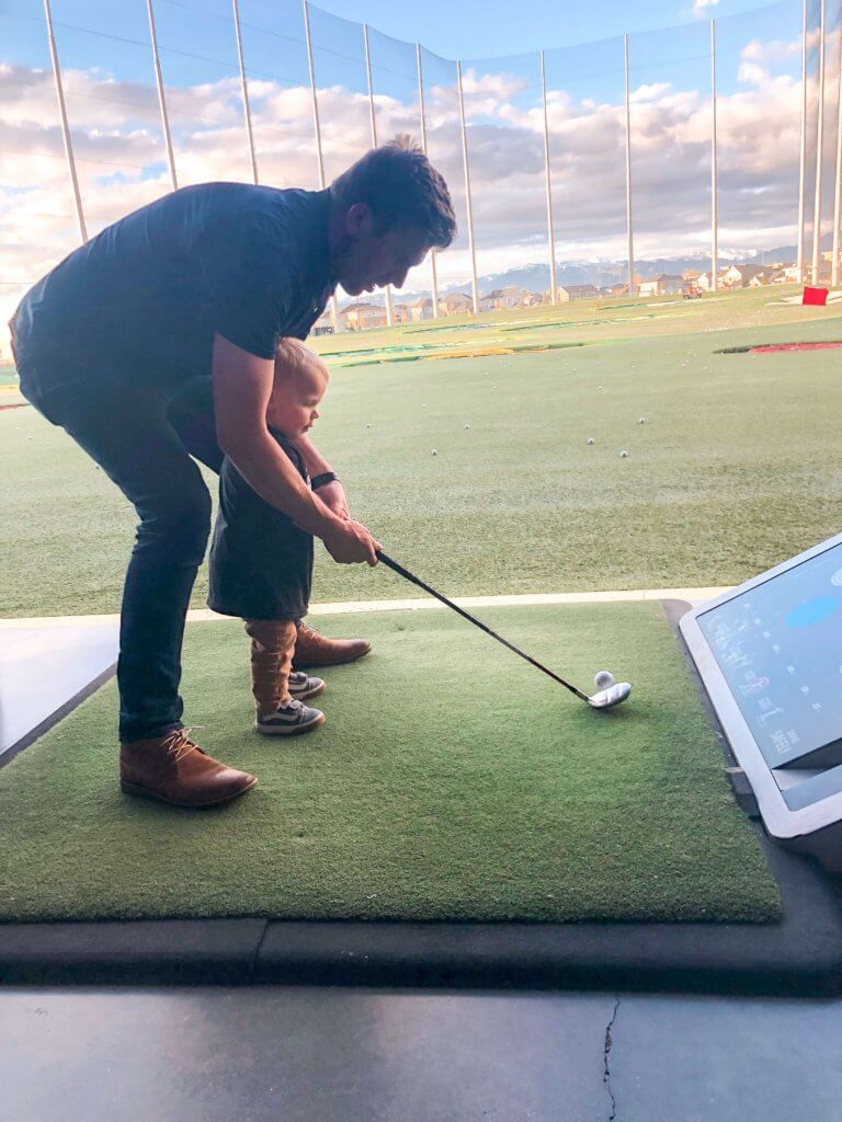 2 year old swinging golf club at Topgolf